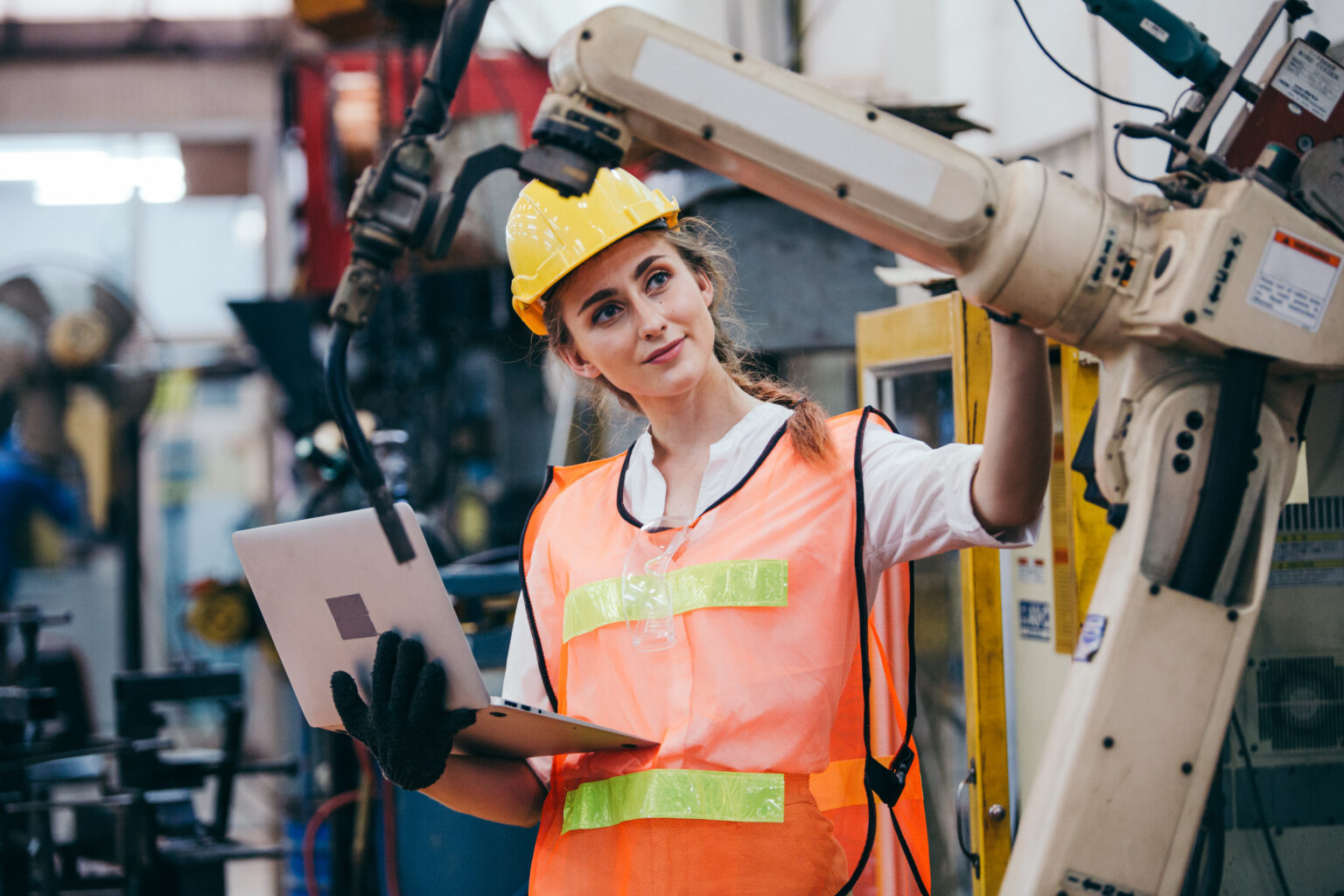 Female industrial engineer or technician worker in hard helmet and